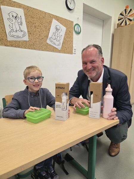 Bild vergr&ouml;&szlig;ern: Das Foto zeigt Landrat Björn Demmin bei der Übergabe der Brotdosen und der Trinkflaschen zusammen mit dem Schüler Luan Kock.
